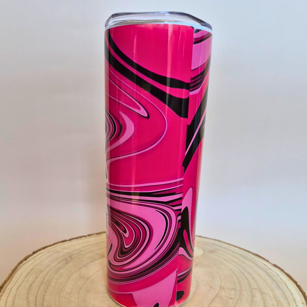A tall, slim tumbler with a vibrant pink, black, and magenta marble swirl pattern, shown on a wooden slice coaster against a white background 