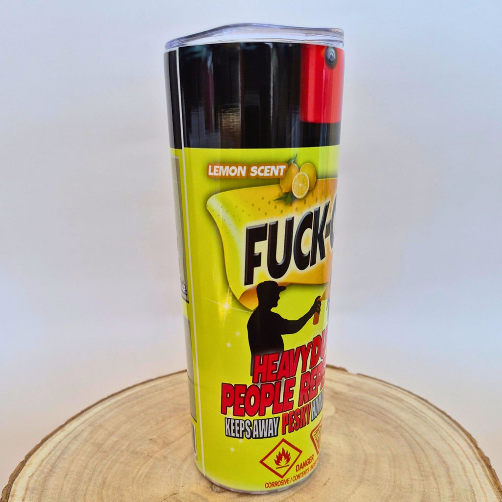 A cylindrical canister of adult novelty product in lemon scent, featuring a bright yellow label with bold black and red text, photographed standing upright on a round wood slice against a plain light background.