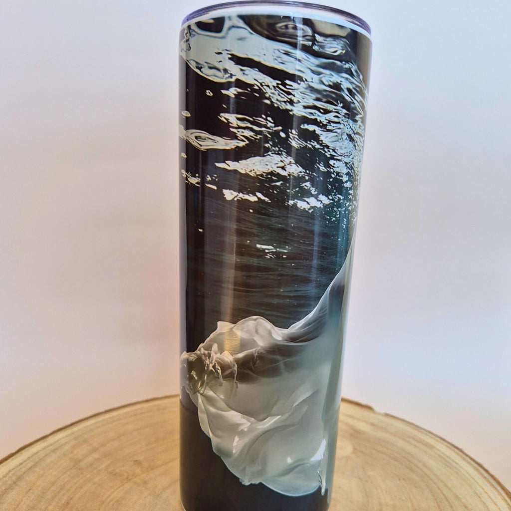 A tall, slim tumbler with a black and gray abstract watercolor design, resting on a round wooden slice against a white background with 'Memory Metal' watermarks.